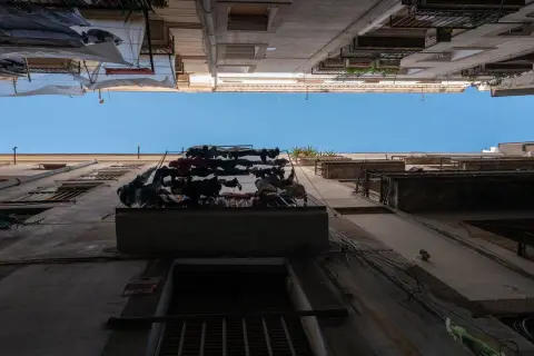 Vue verticale entre deux façades avec du linge étendu sur un balcon, Barcelone
