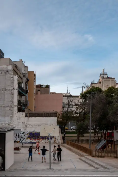 Enfants jouant au ballon sur un terrain entre des immeubles, Barcelone