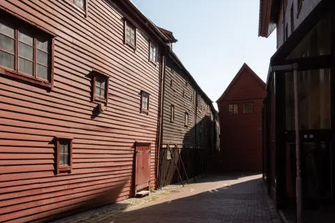 A lane lined with dark red wooden houses, Bergen