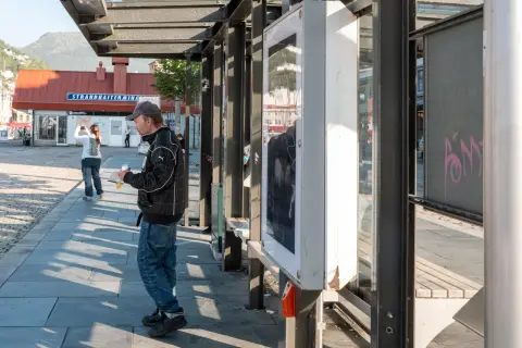 A man waiting under a bus shelter near the Strandkaien terminal, Bergen