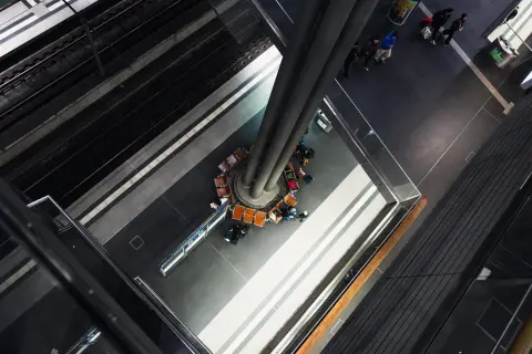 Vue plongeante sur un quai de gare et un pilier central entouré de voyageurs, Berlin