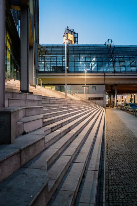 Escalier de pierre montant vers la gare centrale illuminée au crépuscule, Berlin