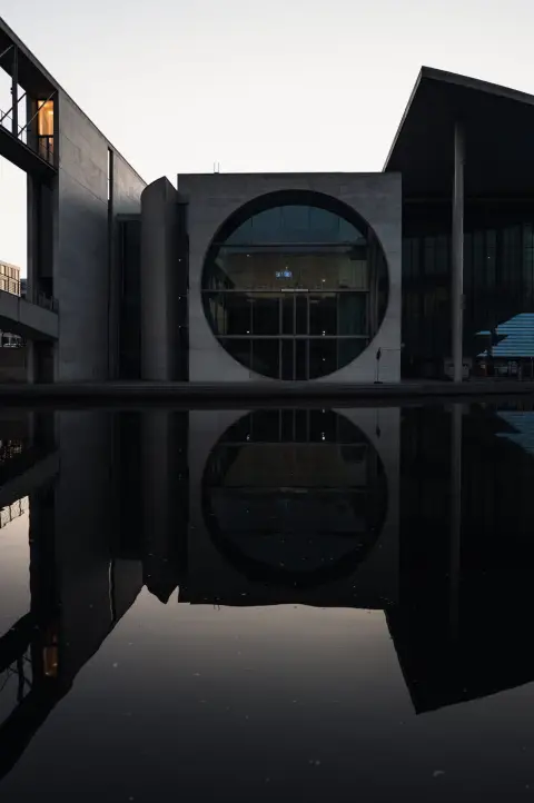 Fenêtre circulaire d'un bâtiment gouvernemental se reflétant dans l'eau au crépuscule, Berlin