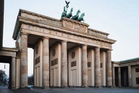 Vue d'angle sur les colonnes et le fronton sculpté de la porte de Brandebourg, Berlin