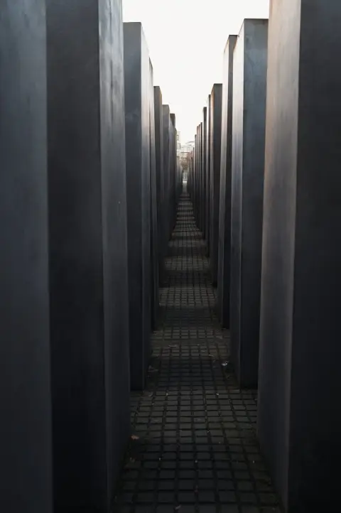 Couloir étroit entre les stèles grises du mémorial de l'Holocauste, Berlin
