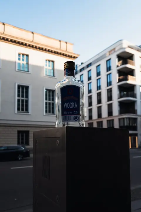Petite bouteille de vodka posée en évidence sur une borne de rue, Berlin