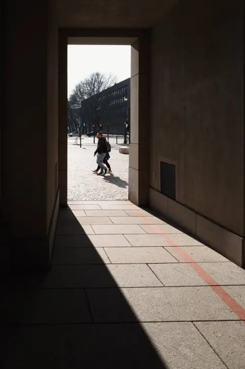 Silhouettes de passants dans l'encadrement lumineux d'un porche, Berlin