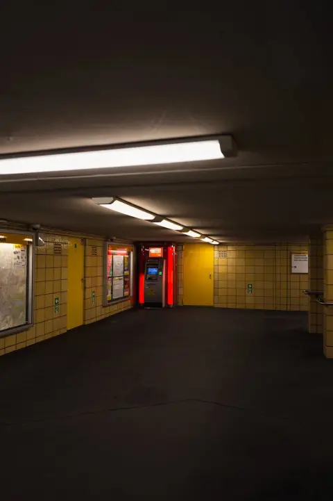 Couloir souterrain carrelé de jaune menant vers un distributeur illuminé, Berlin