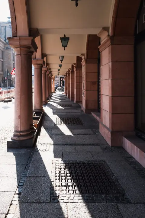 Colonnade de grès rouge et lanternes suspendues le long d'un trottoir, Berlin