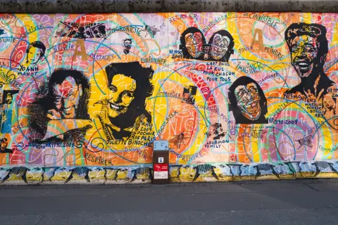 Fresque colorée de l'East Side Gallery mêlant portraits peints et mots inspirants, Berlin
