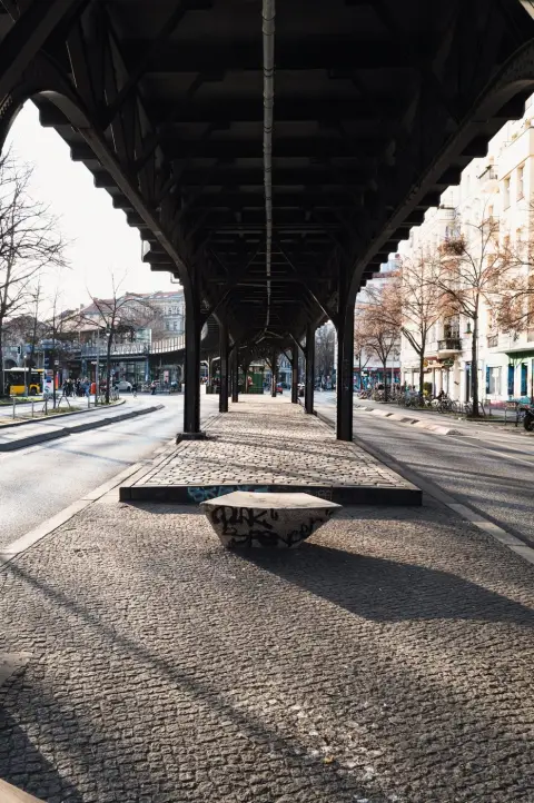 Viaduc ferroviaire métallique surplombant un banc de béton taggé, Berlin