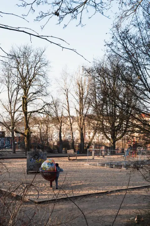 Enfant jouant sur une structure ronde et graffée dans une aire de jeux, Berlin