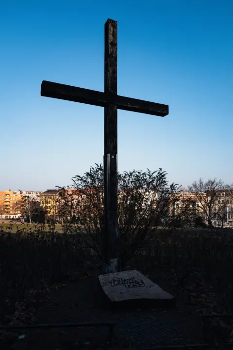 Croix commémorative en bois plantée au milieu d'un parterre d'arbustes, Berlin