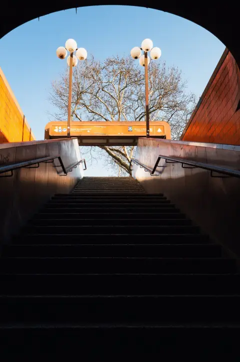 Vue depuis un escalier souterrain vers un arbre et des lampadaires ronds, Berlin