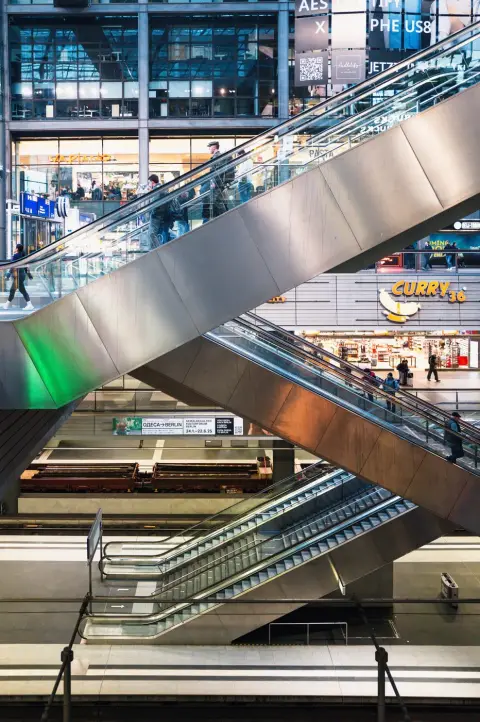 Escalators croisés menant vers les boutiques et enseignes de la gare, Berlin