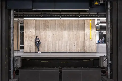 Personne seule adossée à un mur de marbre dans une station de métro, Bruxelles
