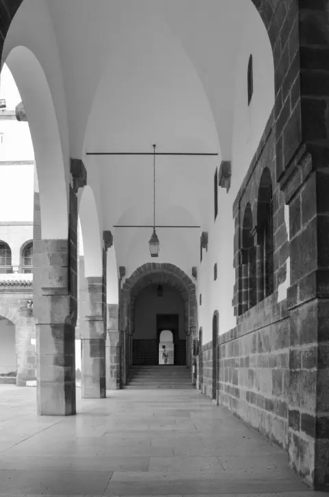 Galerie voutee avec lanterne suspendue et silhouette lointaine, Casablanca