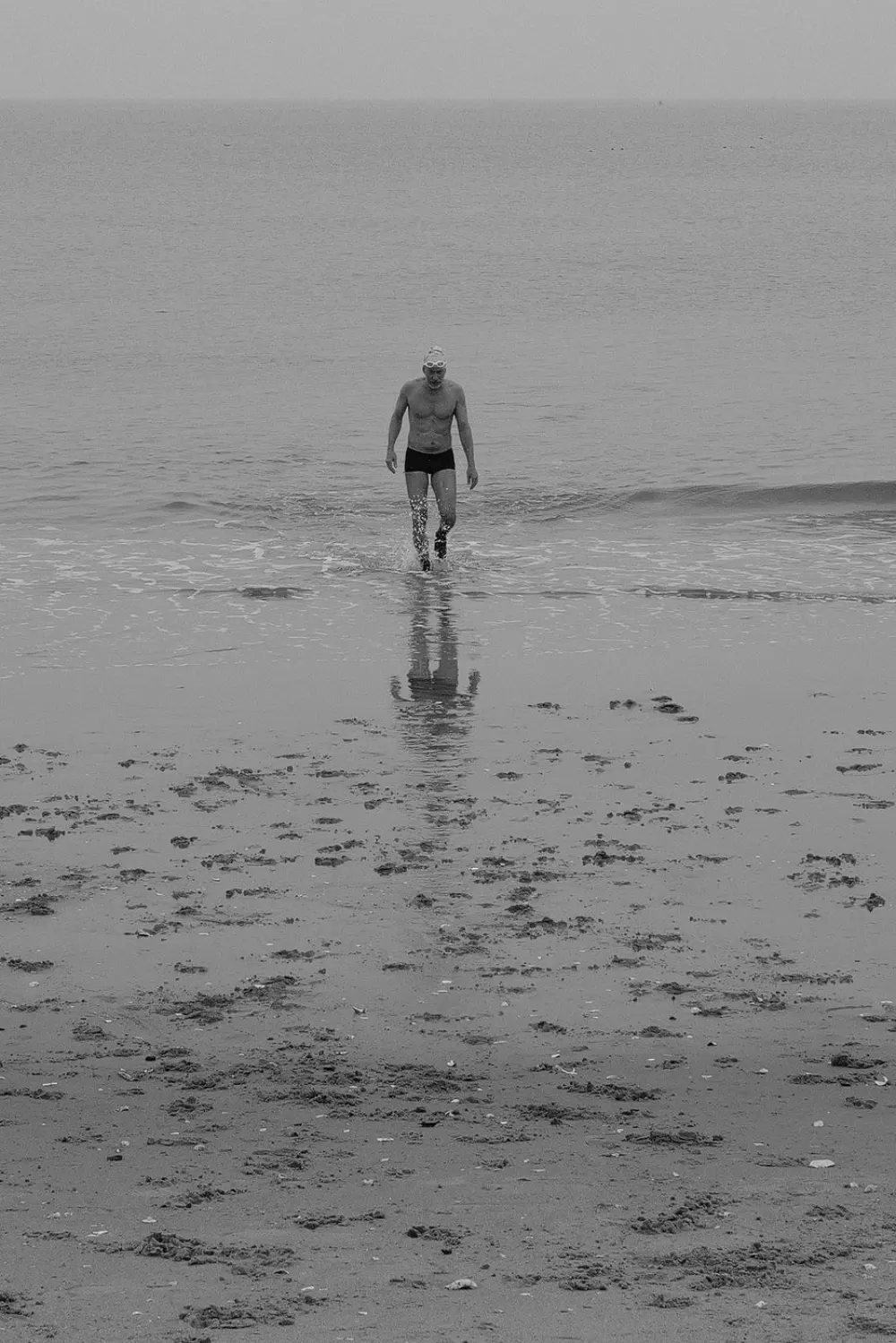 Nageur sortant de l'eau, sa silhouette se refletant sur le sable mouille, Coney Island