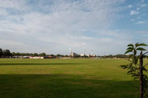 A vast playing field under a mackerel sky, chimneys on the horizon, Copenhagen