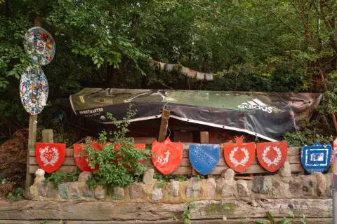 A row of painted shields beneath an upturned boat, Christiania, Copenhagen