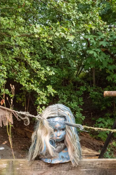 A silver doll’s head with blond hair resting on a fence, Christiania, Copenhagen