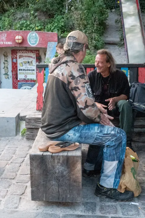 Two men talking on a wooden bench, Christiania, Copenhagen