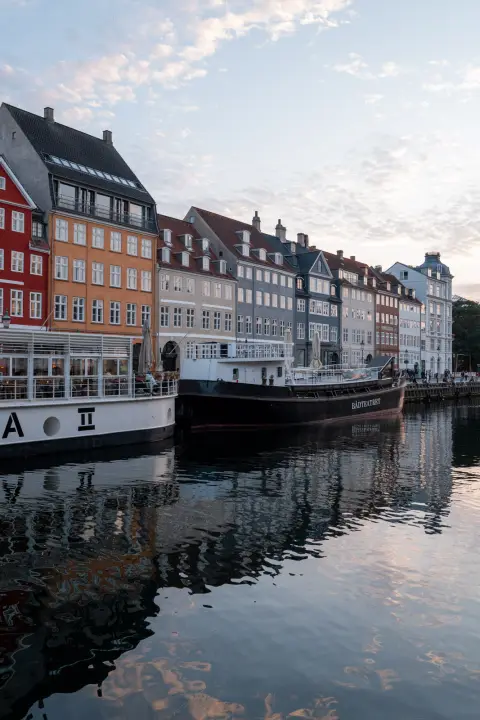 The colourful houses of Nyhavn reflected in the canal at dusk, Copenhagen