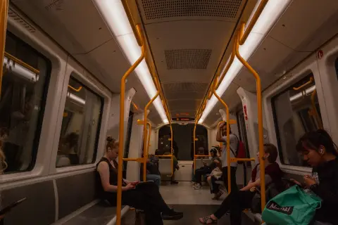 Passengers seated in a metro carriage with yellow handrails, Copenhagen
