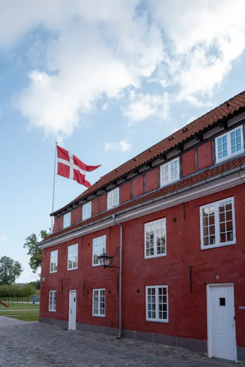 The Danish flag flying in front of the red barracks of the Kastellet, Copenhagen