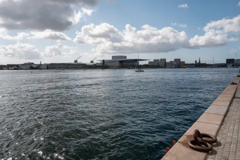 The harbour and the Opera House on the far bank, a mooring ring in the foreground, Copenhagen
