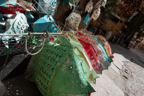 Poissons de métal peint suspendus devant une boutique, L’Île-Rousse, Corse