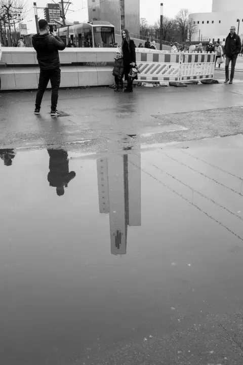 Reflet d'un couple et d'un enfant dans une flaque, place mouillee, Düsseldorf
