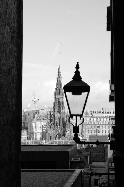 Old lantern at the end of a dark close, the Scott Monument in the distance, Edinburgh