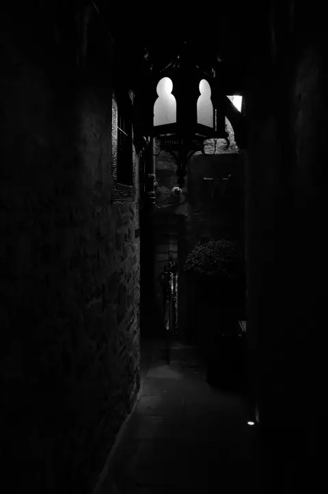 Pitch-dark close under a wrought-iron lantern, Edinburgh