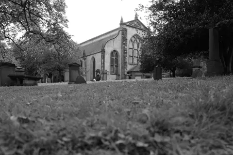 Church and gravestones seen from grass level, Edinburgh