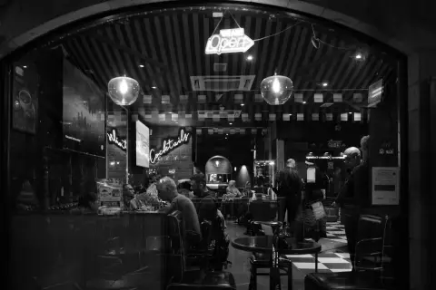 Lit bar seen through an arch, customers at the counter, Edinburgh