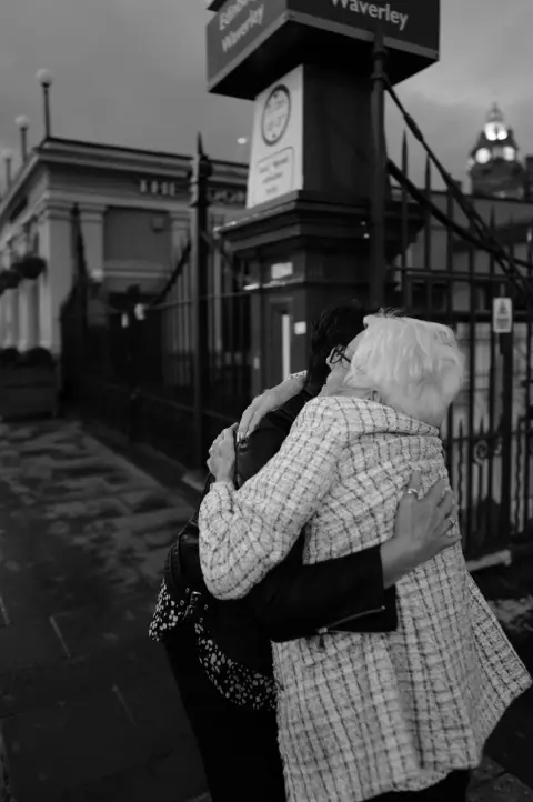 Two women hugging at the Waverley station entrance, Edinburgh