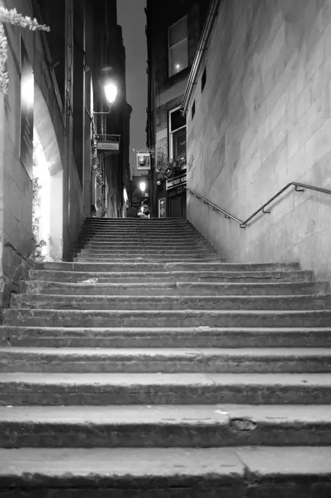 Stone stairway between two walls under a lit street lamp, Edinburgh