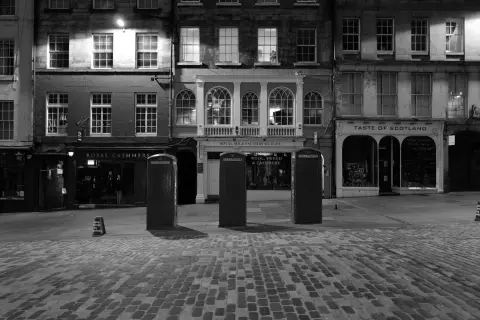 Cobbled square at night, three kiosks in a row, Edinburgh