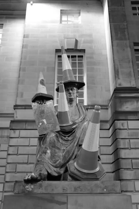 Seated statue crowned with traffic cones, Edinburgh