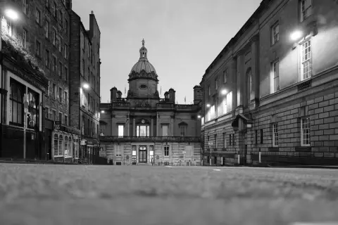Empty street leading to a domed building, street lamps lit, Edinburgh