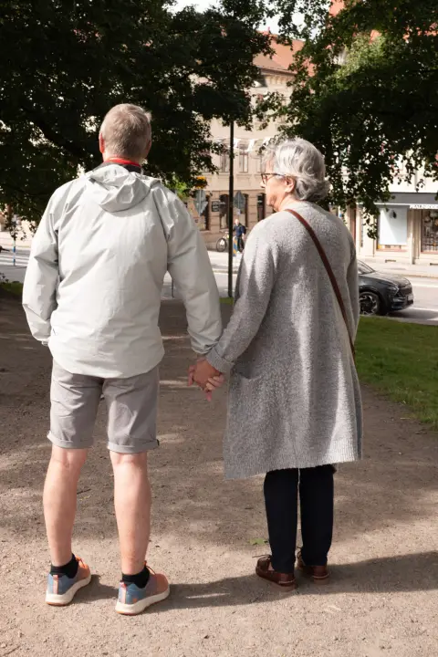 An elderly couple holding hands, seen from behind, Gothenburg