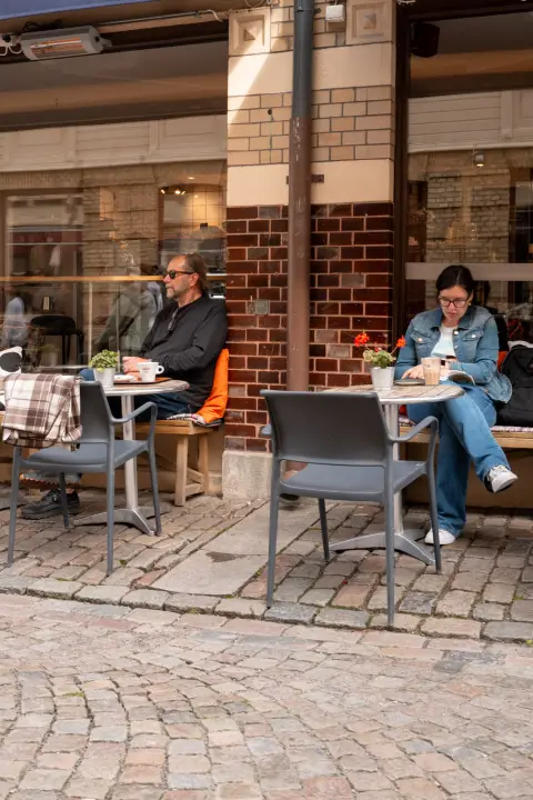 Customers on a terrace in front of a brick facade, Gothenburg