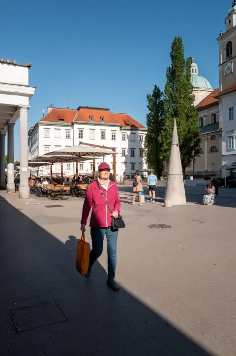 Passante en veste rose traversant la place devant le dome de la cathedrale, Ljubljana