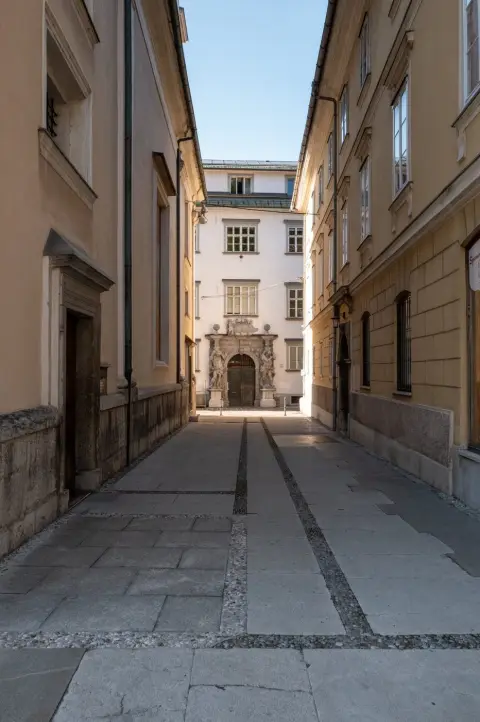Passage silencieux menant a un portail orne de statues, Ljubljana