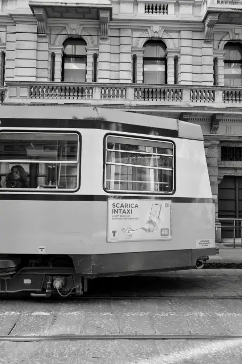 Tramway vintage publicitaire pour une application de taxi, passagère à la fenêtre, Milan