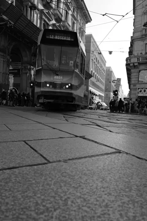 Tramway de la ligne 12 approchant sur les rails au milieu des passants, Milan