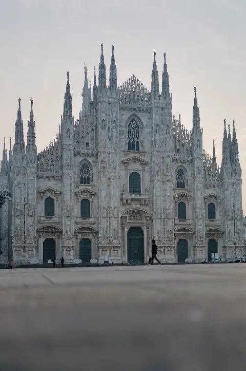 Façade gothique de la cathédrale du Duomo, silhouette solitaire au petit matin, Milan