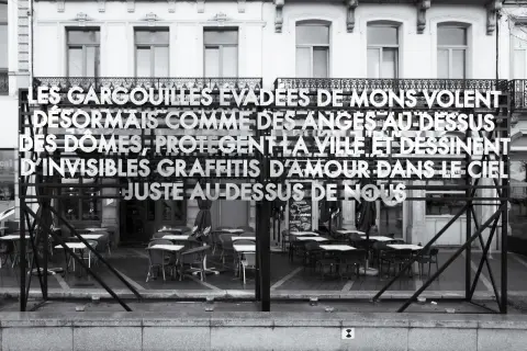 Une phrase en grandes lettres devant les terrasses vides de la Grand-Place : « Les gargouilles évadées de Mons volent désormais comme des anges au-dessus des dômes », Mons
