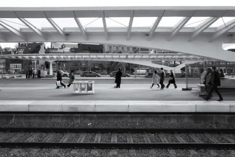 Des voyageurs traversent le quai sous la verrière de la gare, Mons